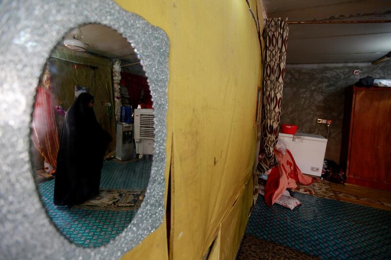 Widow Fatam Hadi Jabr, 56, is seen through a mirror as she prays during Ramadan in Najaf, Iraq.  Reuters