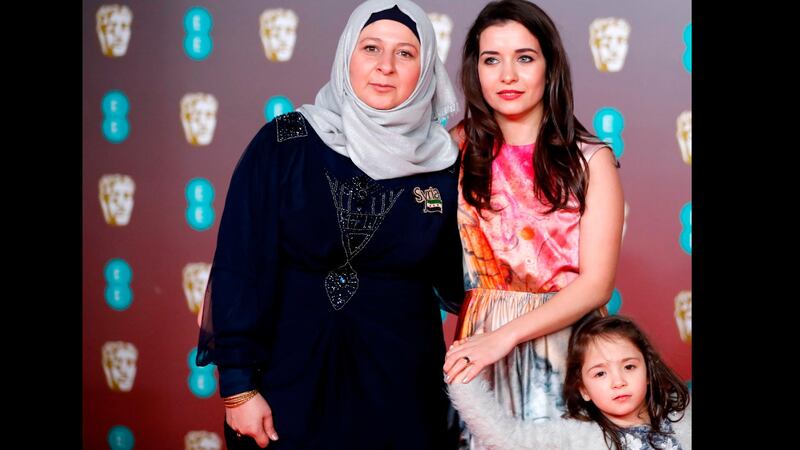Syrian filmmaker Waad al-Kateab, centre, and Sama, right, pose on the red carpet with their friend Afra (left) upon arrival at the Bafta British Academy Film Awards at the Royal Albert Hall in London on February 2, 2020. AFP 