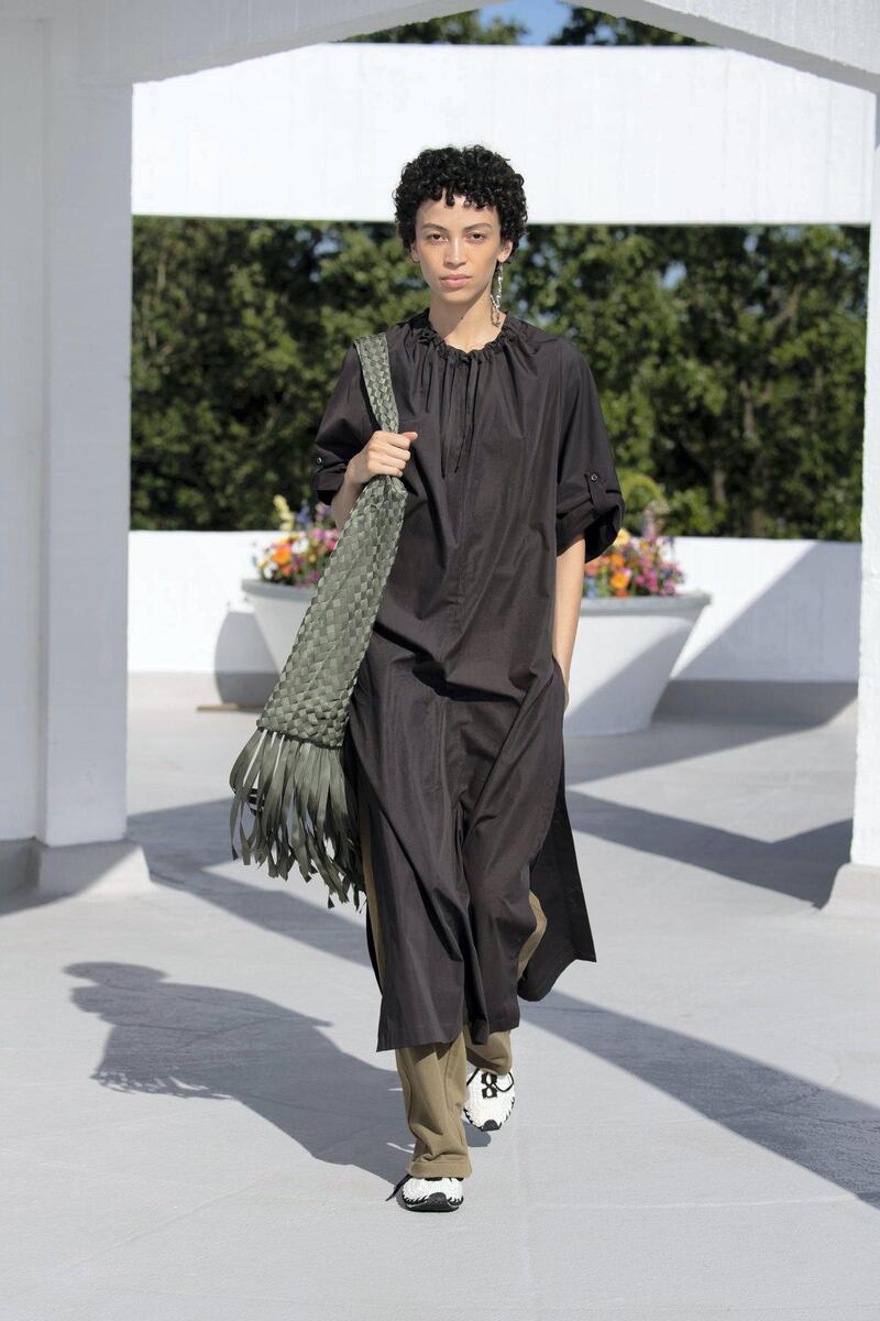 A gathered-at-the-neck dress is teamed with a woven bag in petrolled green. Courtesy Qasimi