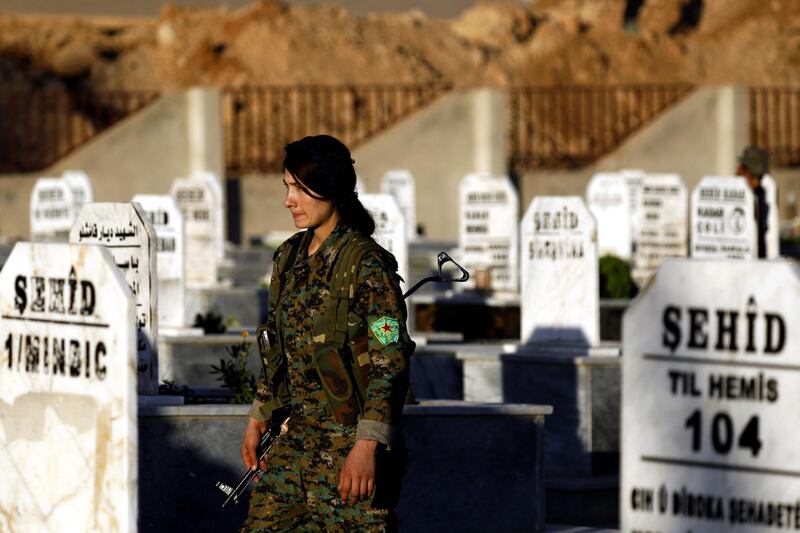 A fighter from the Syrian Democratic Forces (SDF) attends the funeral of one of their commanders, killed a day earlier in the town of Hajin during battles against the Islamic State (IS) group, in the Kurdish-controlled city of Qamishly in northeastern Syria, on October 29, 2018.   The Islamic State group ousted a US-backed coalition of Kurdish and Arab forces from its holdout in eastern Syria on October 28, killing dozens of fighters, a monitoring group said. / AFP / Delil SOULEIMAN
