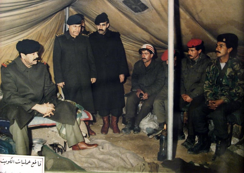 A reproduction of a picture displayed at the Nasr or Victory Museum in Baghdad shows Iraqi President Saddam Hussein (L) visiting Iraqi troops at a military camp in occupied territory in Kuwait after the August 2, 1990 invasion of the Gulf emirate. The Nasr Museum is dedicated to the Iraqi leader and includes painting made of and for him, uniforms and weapons he used during the 1991 Gulf War and official gifts he received during his two-decade reign. The 10th anniversary of the Gulf War, when a US-led international coalition unleashed a war to liberate Kuwait from Iraqi occupation, is coming up 16 January 2001. AFP PHOTO/Karim SAHIB
AFP PHOTO AFP/KARIM SAHIB/mro (Photo by AFP)