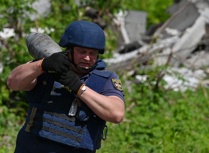 A Ukrainian bomb disposal worker carries unexploded ordnance during mine clearance work in the village of Yahidne, in the liberated territories of the Chernihiv region. AFP