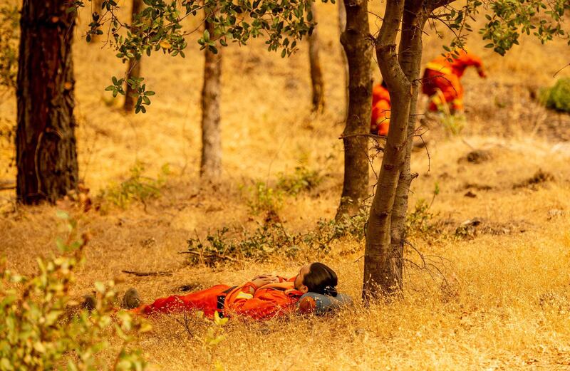 Inmate firefighters take a rest during the Bear fire, part of the North Lightning Complex fires, in unincorporated Butte County, California.  AFP