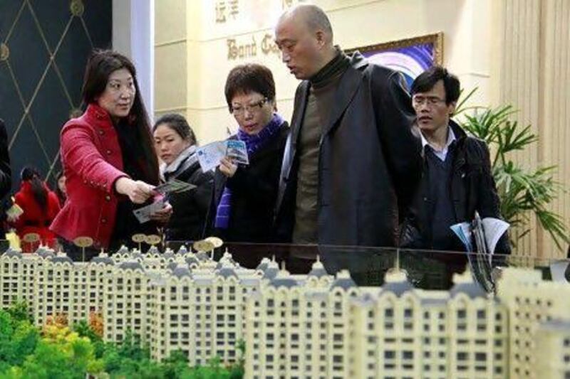 Visitors look at models and floor plans of new residential developments at the Spring Real Estate Fair in Shanghai on March 18. Qilai Shen / EPA