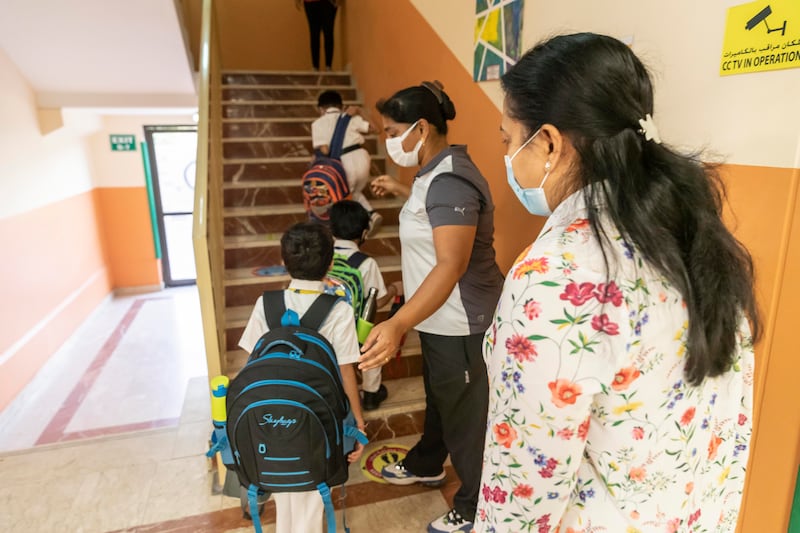 Teachers and staff greet incoming pupils.