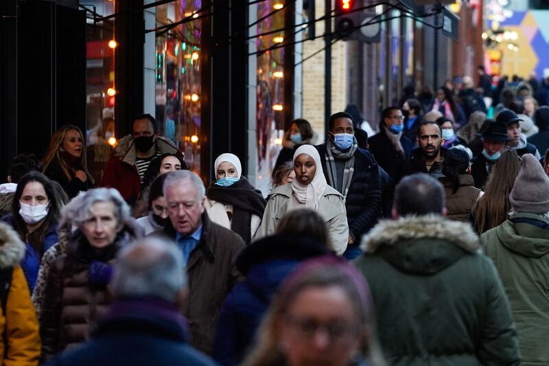 Some shoppers wear face coverings as they walk along Oxford Street in central London. AFP