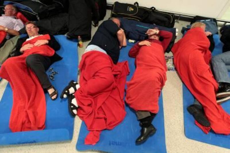 Passengers sleep on the floor in the main terminal at Edinburgh Airport, in Scotland May 24, 2011. Ash from an Icelandic volcano forced the cancellation of dozens of flights to and from Scotland on Tuesday but Ireland's Ryanair said it would protest against "unnecessary" restrictions. REUTERS/David Moir (BRITAIN - Tags: TRANSPORT DISASTER ENVIRONMENT TRAVEL) *** Local Caption ***  DMR016_ICELAND-VOLC_0524_11.JPG