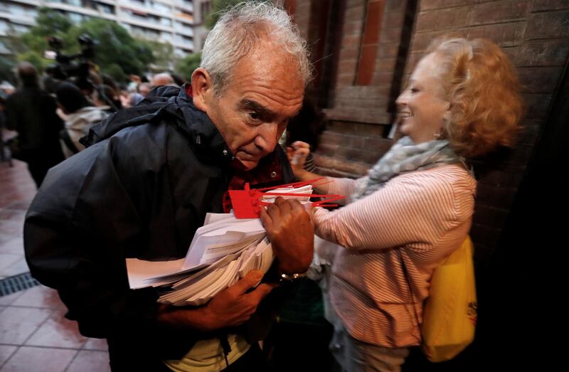 A man holds ballots at a polling station for the banned independence referendum in Barcelona, Spain. Yves Herman / Reuters