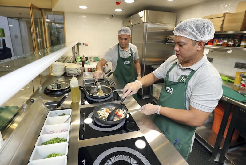 Abu Dhabi, United Arab Emirates - September 15, 2019: Chef Raymond (R) creates cajun fiesta pasta while Chef Edward creates a vegan Mojo wrap. A look at the newly opened Sweet Greens café. They have a special focus on being healthy and environmentally friendly. Sunday the 15th of September 2019. Rihan Heights, Abu Dhabi. Chris Whiteoak / The National