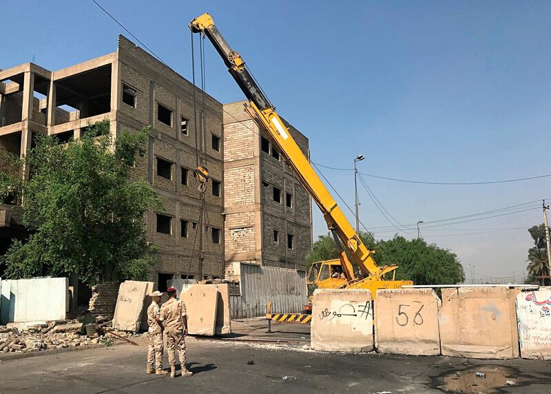 Iraqi security forces remove concrete blast walls that were cutting the streets in the protest site area of Baghdad, a day after calmness was restored in the Iraqi capital. AP Photo