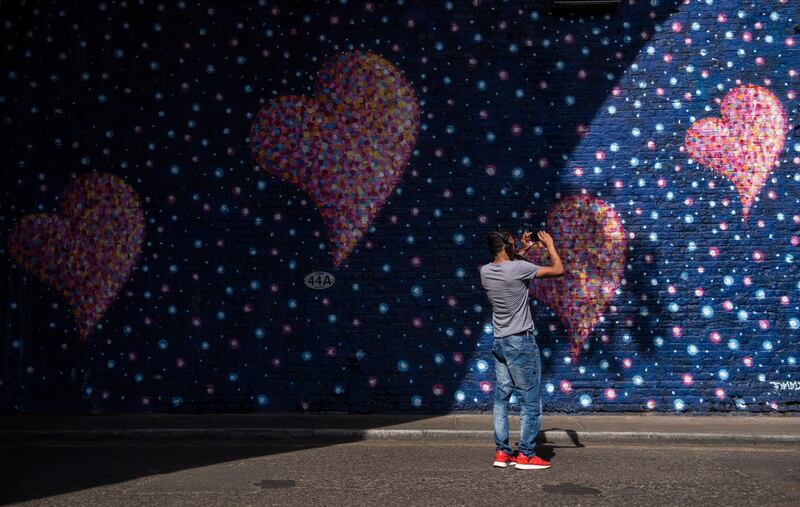 A man takes a photo of a mural in a tunnel near Borough Market painted by graffiti artist James Cochran, also known as Jimmy C, that commemorates the victims of the London Bridge terror attack on the first anniversary of the attack at Borough Market in London, England. Chris J Ratcliffe / Getty Images