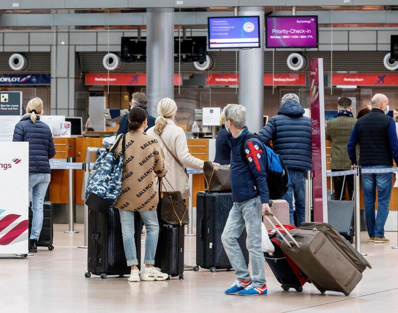 Passengers check in at Hamburg Airport, Germany, for flight Eurowings EW 7588 to Palma de Mallorca on Sunday, March 14, 2021. Due to sharply falling Corona infection figures, the German government lifts travel restrictions for Mallorca, Spain's most important tourism island. (Markus Scholz/dpa via AP)