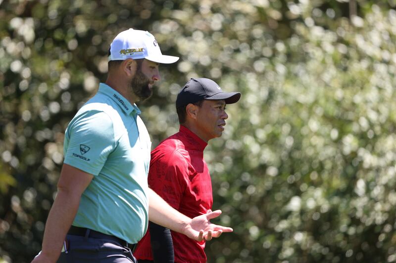 Tiger Woods and Jon Rahm walk down the fairway on the 11th hole during the final round of the Masters. EPA