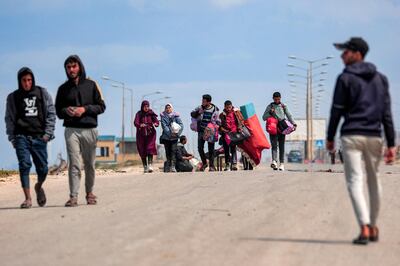 Displaced people fleeing from Gaza city walk along the coastal road towards southern Gaza. AFP