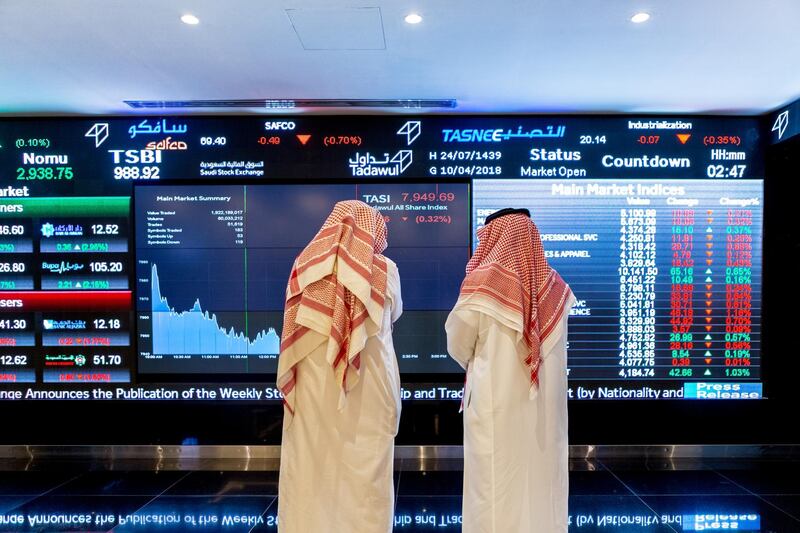 Visitors look at stock price information displayed on a digital screen inside the Saudi Stock Exchange, also known as the Tadawul, in Riyadh, Saudi Arabia, on Tuesday, April 10, 2018. Foreign investors bought more Saudi stocks in March than ever before in anticipation of the kingdom’s upgrade to emerging-market status. Photographer: Abdulrahman Abdullah/Bloomberg