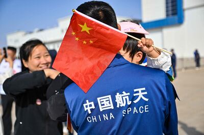 A child holds a Chinese flag while waiting for the launch of the Long March-2F rocket. AFP