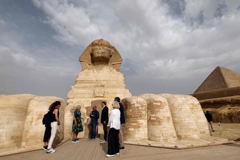 Mrs Biden listens Mr Waziri next to the Sphinx. AFP