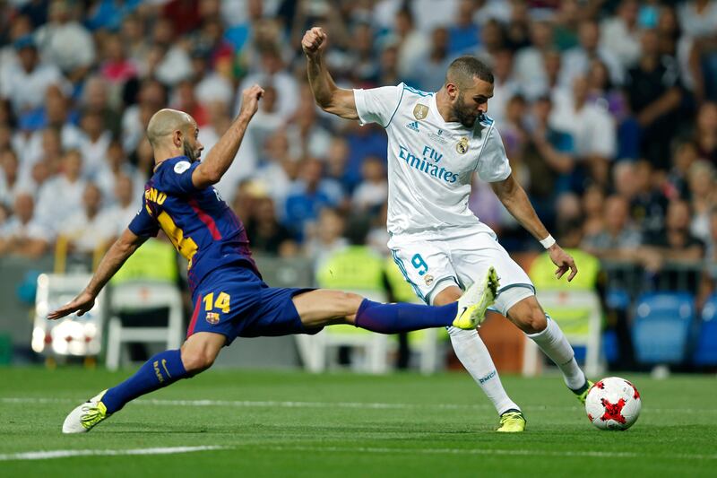 Real Madrid's Karim Benzema is challenged by Barcelona's Javier Mascherano. Francisco Seco / AP Photo