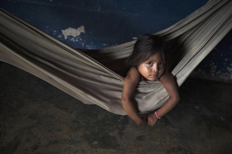 A Yukpa girl rests in a hammock near her grandmother who lies in a malarial fever at their house in Los Angeles del Tukuko community in Venezuela. AFP