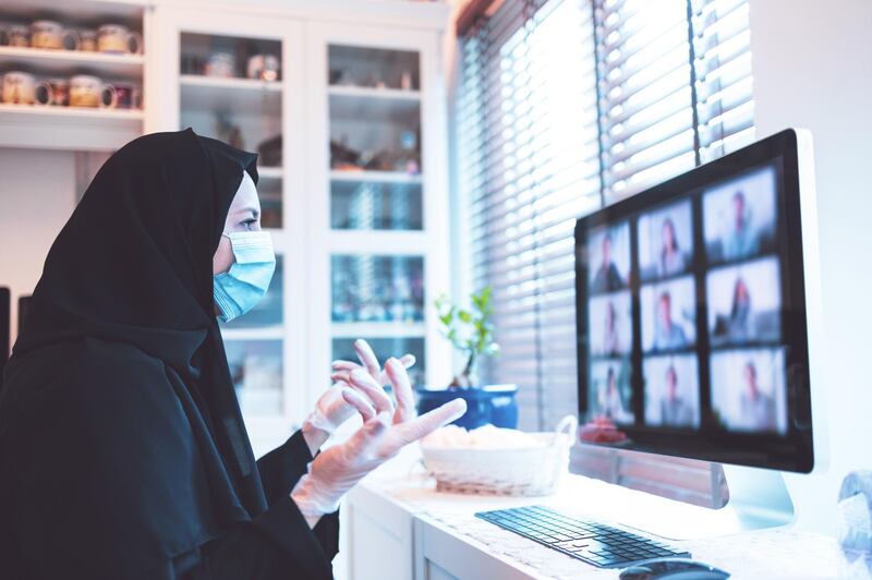 Middle East, Arab, Modern - Middle Eastern Woman talking to her colleagues over a video call from home office setup
