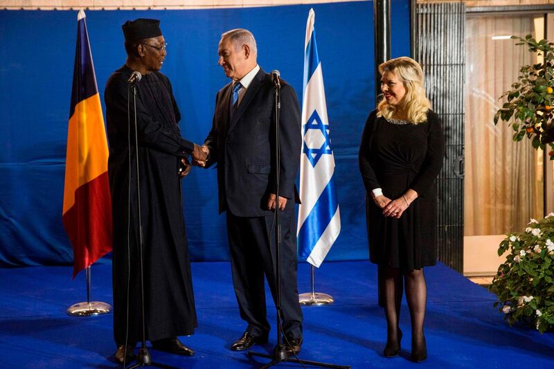 Israeli Prime Minister Benjamin Netanyahu (C) shakes hands with Chadian President Idriss Deby (L), as he and his wife Sara (R) receive the latter for a dinner at the PM's residence in Jerusalem on November 25, 2018. Chadian leader Idriss Deby Itno on November 25 became the first president of his country to visit Israel and pledged a new era of relations when meeting Prime Minister Benjamin Netanyahu decades after ties were severed. / AFP / POOL / Heidi Levine
