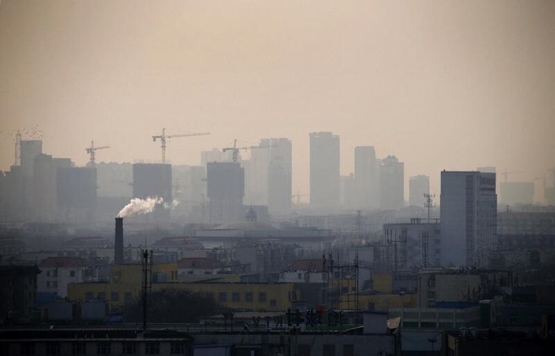 Smoke rises from a chimney among houses on a hazy day in the city centre of Tangshan, Hebei province. Petar Kujundzic / Reuters