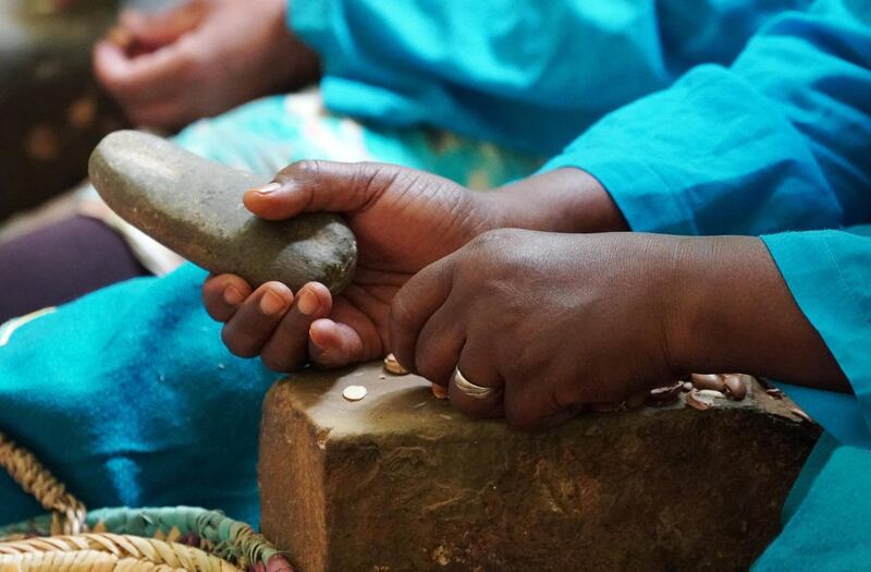 An Amazigh woman crushes argan nuts to extract the kernels, at Women's Agricultural Cooperative Taitmatine, in Tiout, near Taroudant, Morocco June 10, 2021. Picture taken June 10, 2021. REUTERS/Abdelhak Balhaki