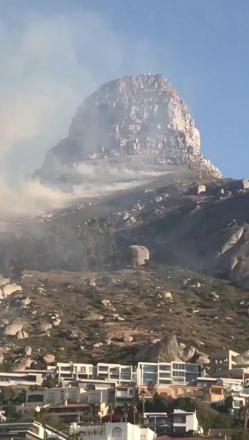 Smoke rises from a burning mountainside in Cape Town. Twitter /@Laura_Bodyzone / via Reuters
