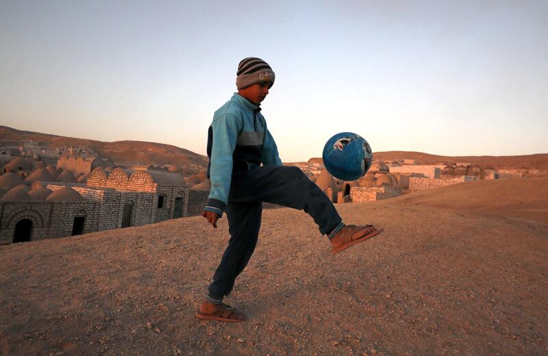 A child controls the ball during a game of football at the graveyards. Reuters