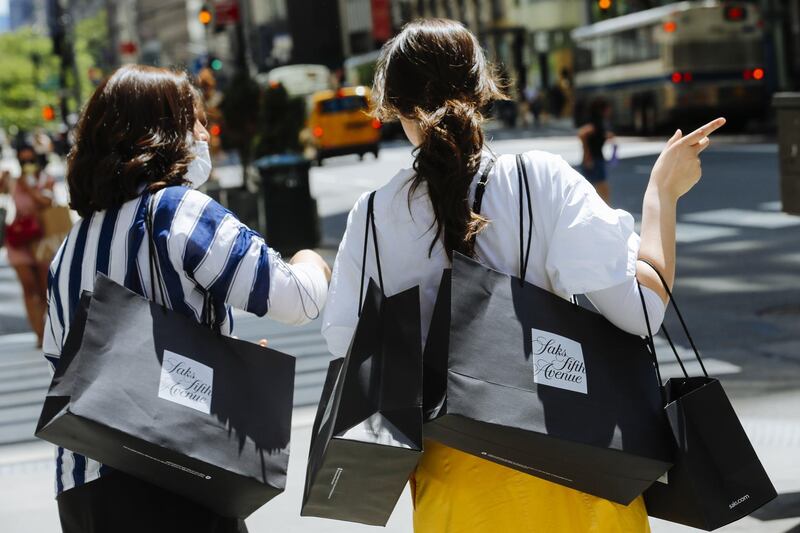 Pedestrians carry shopping bags outside the Saks Fifth Avenue store New York, U.S., on Wednesday, June 24, 2020. New York, New Jersey and Connecticut will require visitors from virus hot spots to quarantine for 14 days Photographer: Angus Mordant/Bloomberg