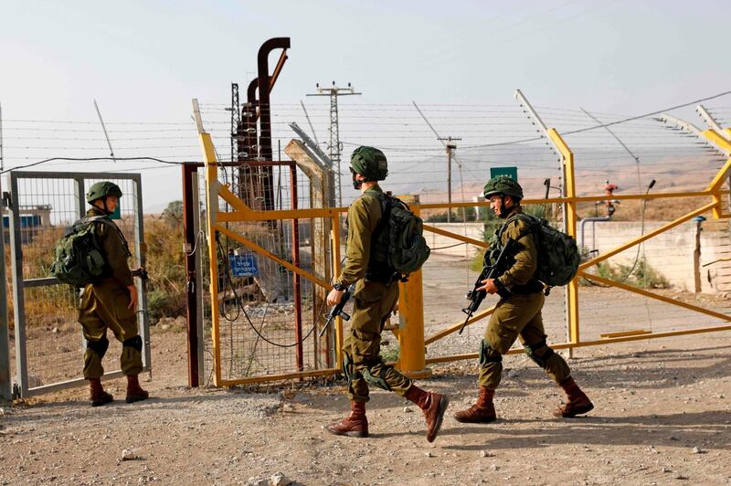 Israeli soldiers patrol the border fence.   AFP