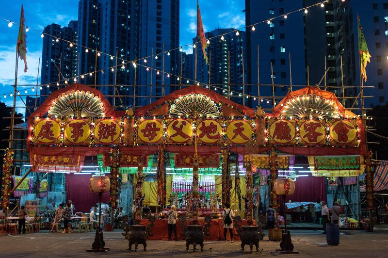 This picture taken on August 17, 2018 shows a traditional makeshift are set up at a playground in the Tsuen Wan district for residents to mark the Hungry Ghost Festival in Hong Kong. - It is believed that the "Gates of Hell" are opened during the seventh month in the lunar calendar to let out the hungry ghosts who then wander in the land of the living while foraging for food. Food offerings are made while paper money and incense sticks are burnt outside homes to keep the spirits of dead ancestors happy and to bring good luck, while Chinese opera performances are given to praise the charitable and pious deeds of deities. (Photo by Philip FONG / AFP)