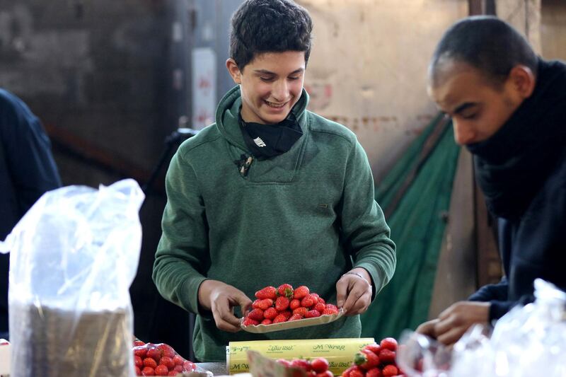 Mohammad, 14, arranges strawberry boxes in one of Amman's popular fruit and vegetable markets. UNICEF says many children do not have internet access for online learning AFP