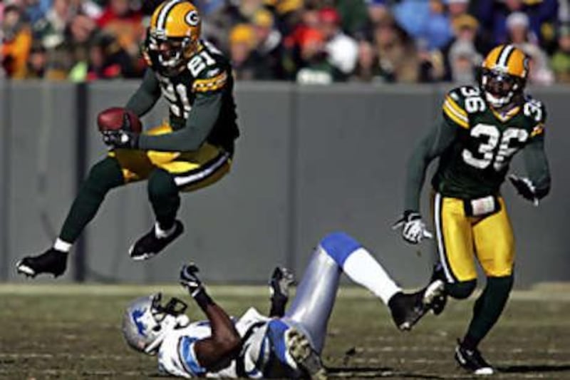 The Packers cornerback Charles Woodson (No 21) intercepts a pass during the Lions' defeat to Green Bay.