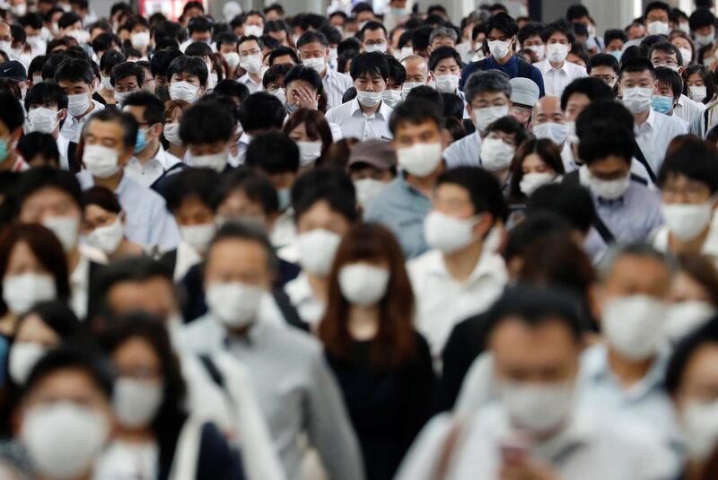 People wearing protective masks make their way during rush hour at a railway station in Tokyo, Japan. Reuters