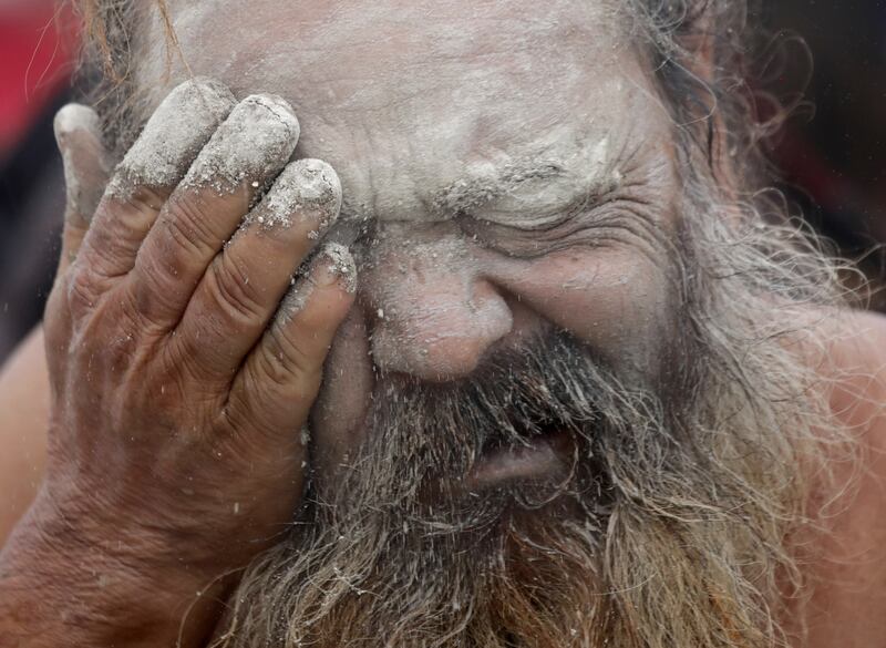 An Indian monk performs the ritual of applying mud dust on his face. EPA
