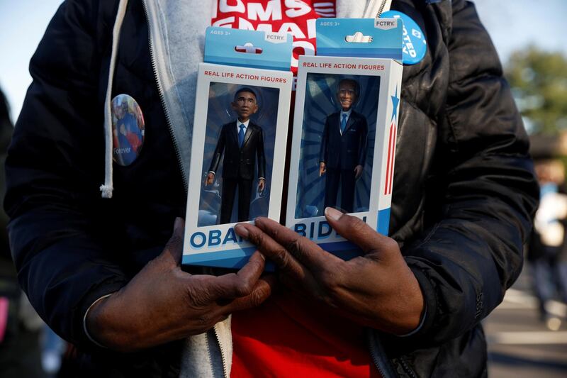 A person holds real life action figures depicting democratic US presidential nominee and former Vice President Joe Biden and former US President Barack Obama during a campaign canvas kickoff in Bloomfield Hills, Michigan, US, October 31, 2020. Reuters