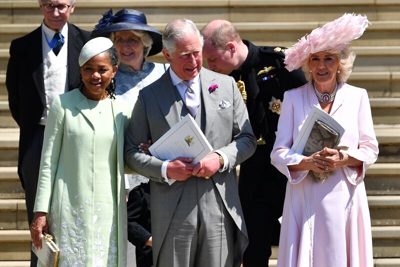 The queen consort, in a pink dress and a feathered hat, with Meghan's mother Doria Ragland and King Charles, leaves St George's Chapel in Windsor after the wedding of Prince Harry and Meghan on May 19, 2018. Getty Images