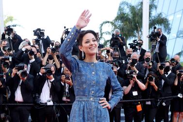 French actress and producer Marion Cotillard waves as she arrives for the screening of for the film "Bigger Than Us" at the 74th edition of the Cannes Film Festival in Cannes, southern France, on July 10, 2021.  (Photo by Valery HACHE  /  AFP)