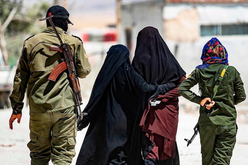 An internal security patrol escorts women, reportedly wives of Islamic State (IS) group fighters, in the al-Hol camp in al-Hasakeh governorate in northeastern Syria, on July 23, 2019. Stabbing guards, stoning aid workers and flying the Islamic State group's black flag in plain sight: the wives and children of the 'caliphate' are sticking by the jihadists in a desperate Syrian camp. Months after the defeat of the jihadist proto-state, families of IS fighters are among 70,000 people crammed into the Kurdish-run Al-Hol camp in northeastern Syria. - TO GO WITH AFP STORY BI DELIL SULEIMAN
 / AFP / DELIL SOULEIMAN / TO GO WITH AFP STORY BI DELIL SULEIMAN
