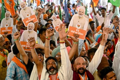 Supporters of the Bharatiya Janta Party (BJP) holding cut-outs of India's Prime Minister and their leader, Narendra Modi, shout slogans during an election campaign rally in Amritsar. AFP