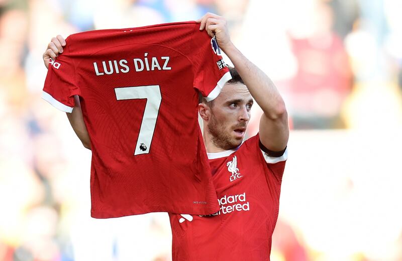Liverpool's Diogo Jota celebrates after scoring against Nottingham Forest by holding up the jersey of teammate Luis Diaz. EPA