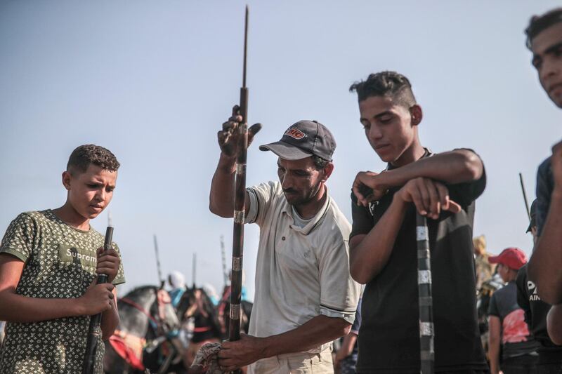 A man helps prepare rifles before being loaded with gunpowder to be used in Tabourida, a traditional horse riding show also known as Fantasia, in the coastal town of El Jadida, Morocco.