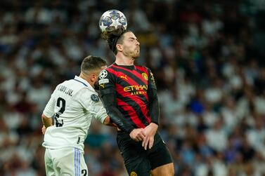 Manchester City's Jack Grealish, right, jumps for the ball with Real Madrid's Dani Carvajal during the Champions League semifinal first leg soccer match between Real Madrid and Manchester City at the Santiago Bernabeu stadium in Madrid, Spain, Tuesday, May 9, 2023.  (AP Photo / Jose Breton)