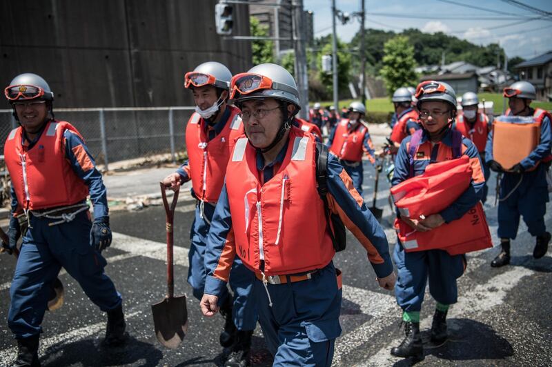 Emergency service workers arrive to search for people following a landslide in Yanohigashi. Getty Images
