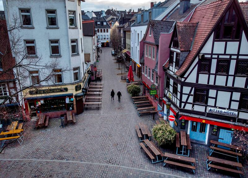 People walk through the quiet Alt Sachsenhausen district in Frankfurt, Germany. AP Photo