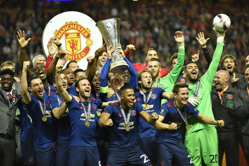 The Manchester United team celebrate with the Europa League trophy. Peter Powell / EPA