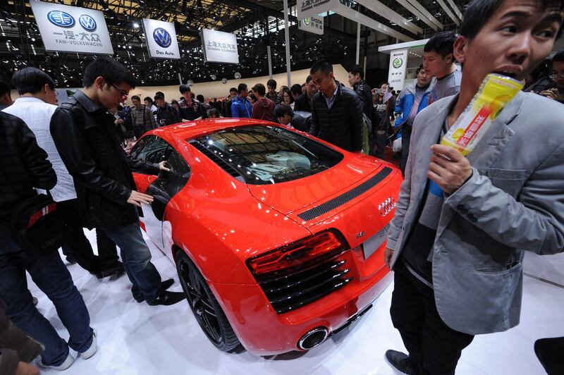 Visitors look at an Audi R8 V8 on the opening day of the Shanghai auto show on April 21, 2013. Chinese buyers swarmed around hundreds of vehicles at the Shanghai auto show at its opening highlighting the importance of the world's largest car market to manufacturers. AFP PHOTO/Peter PARKS
 *** Local Caption ***  958035-01-08.jpg