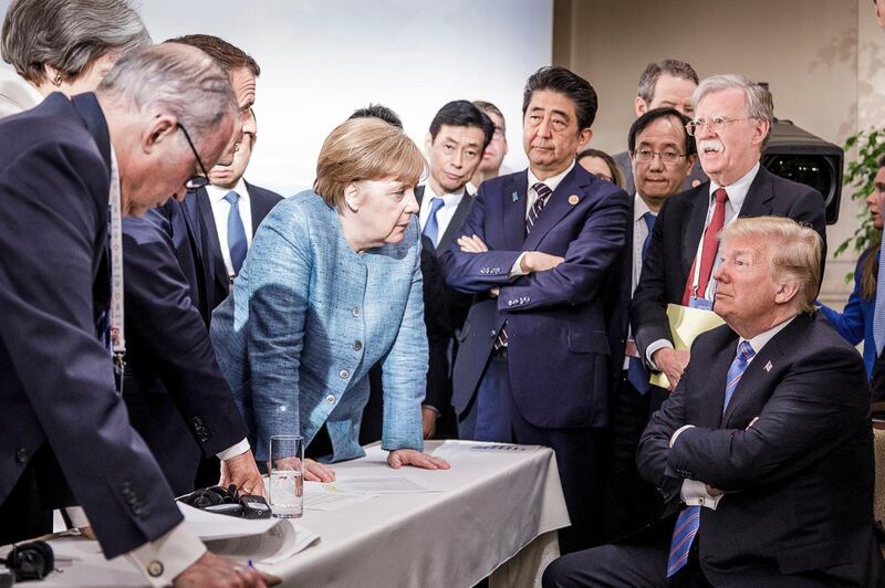 CHARLEVOIX, CANADA - JUNE 9:   In this photo provided by the German Government Press Office (BPA), German Chancellor Angela Merkel deliberates with US president Donald Trump on the sidelines of the official agenda on the second day of the G7 summit on June 9, 2018 in Charlevoix, Canada. Also pictured are (L-R) Larry Kudlow, director of the US National Economic Council, Theresa May, UK prime minister, Emmanuel Macron, French president, Angela Merkel, Yasutoshi Nishimura, Japanese deputy chief cabinet secretary, Shinzo Abe, Japan prime minister, Kazuyuki Yamazaki, Japanese senior deputy minister for foreign affairs, John Bolton, US national security adviser, and Donald Trump. Canada are hosting the leaders of the UK, Italy, the US, France, Germany and Japan for the two day summit. (Photo by Jesco Denzel /Bundesregierung via Getty Images)