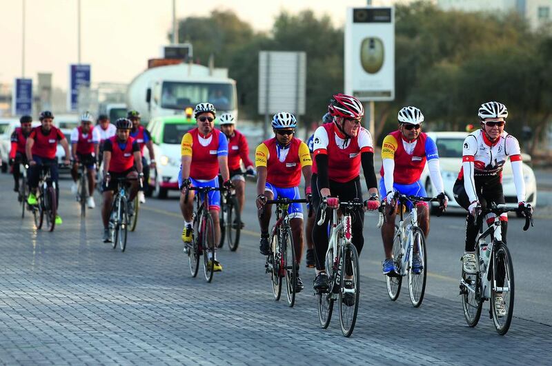 Peter England, chief executive of RAK bank (front left), rides with his employees in Ras Al Khaimah as part of last year’s #cycletoworkuae campaign. Pawan Singh / The National